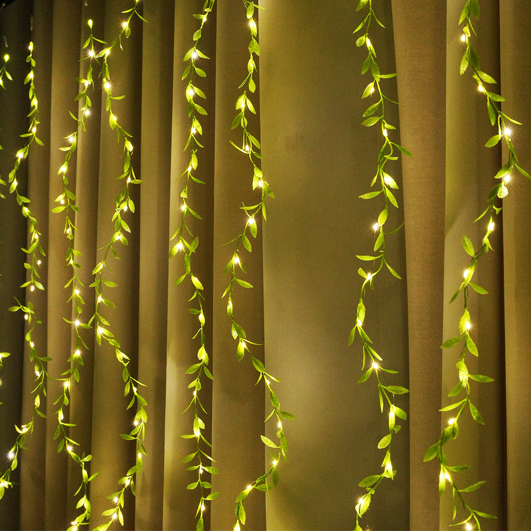 Green vine LED curtain lights with warm white glow for festival décor – Chronos Lights