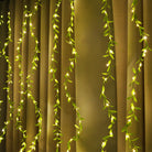 Green vine LED curtain lights with warm white glow for festival décor – Chronos Lights