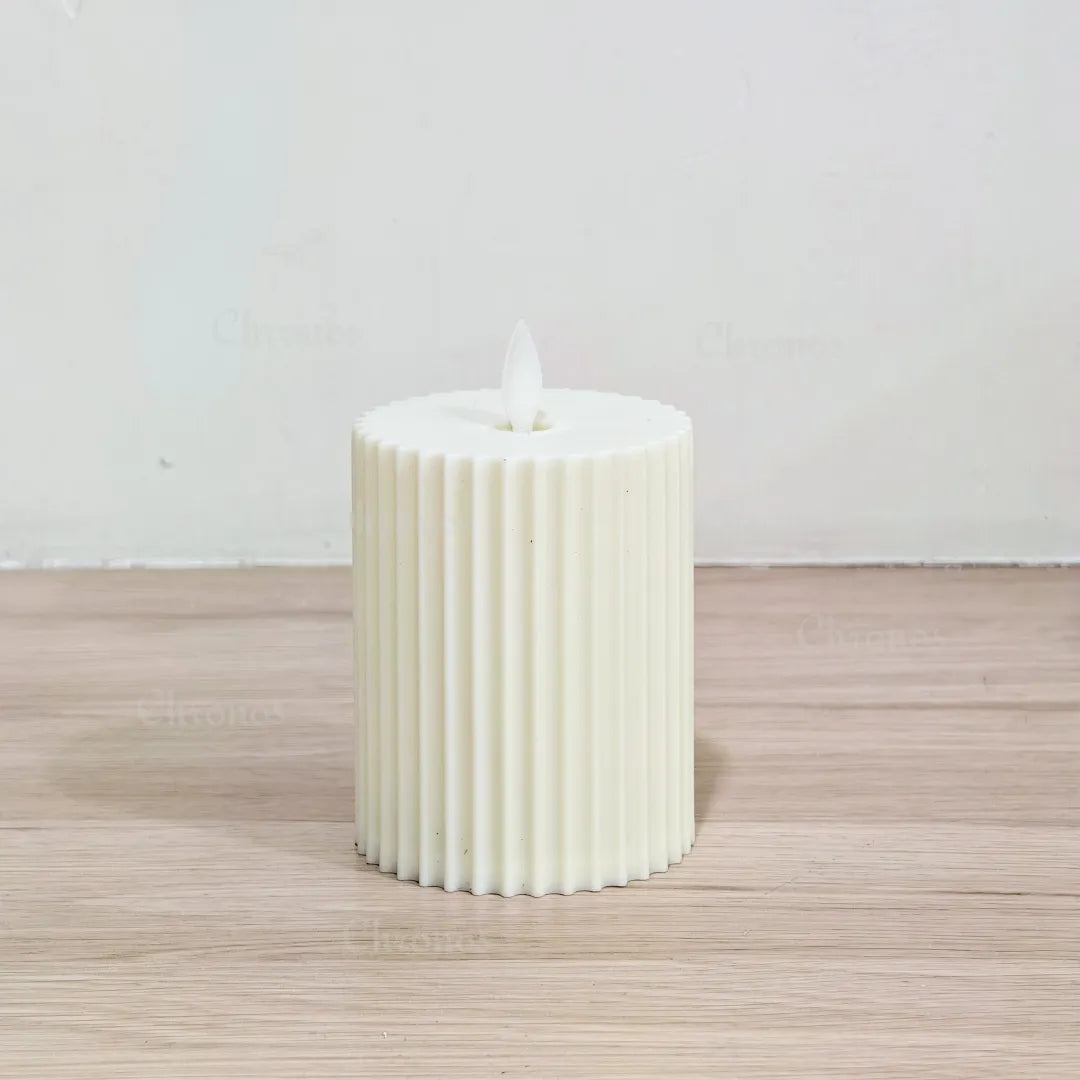 Close-up view of moving wick flame on pleated LED candle