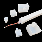 Silicone end caps for LED strip channel with metal mounting clips.