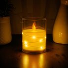 Flameless LED pillar candle featuring moving wick technology and sparkling fairy lights.