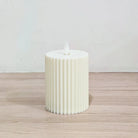 Close-up view of moving wick flame on pleated LED candle