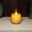 Realistic flickering flame LED pillar candle in golden acrylic glass.