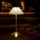 Velora cordless rechargeable table lamp with brushed brass base and pleated fabric shade